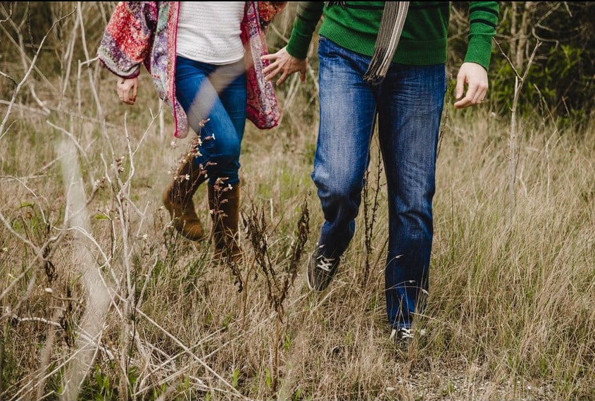 pareja-caminando-cesped-seco